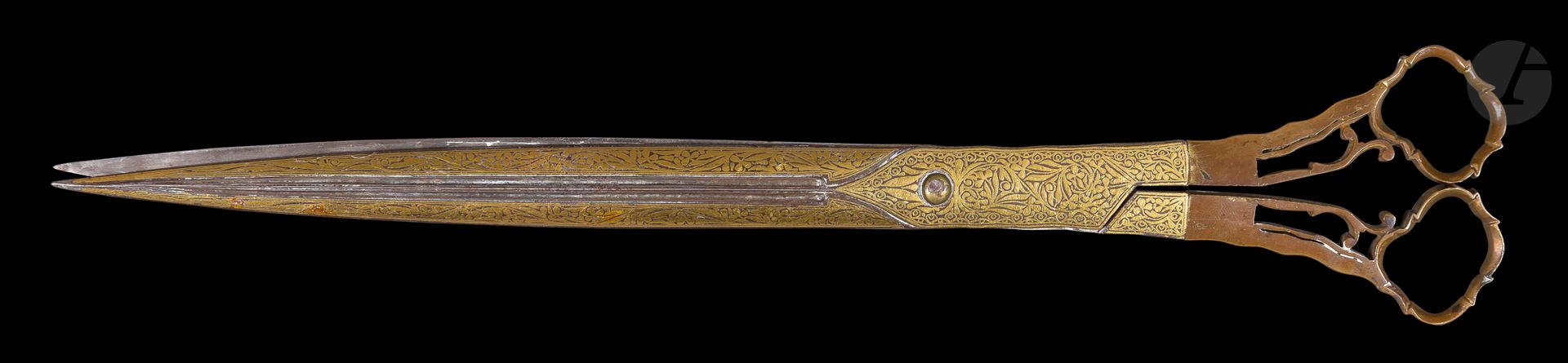 Null 一对书法家的剪刀，奥斯曼土耳其，19世纪
略微弯曲的刀片，中央有一个双沟，由钢制成，两面镶嵌黄金，上面有风格化的植物构图，镀金的圆环有弯曲的边缘。
长&hellip;