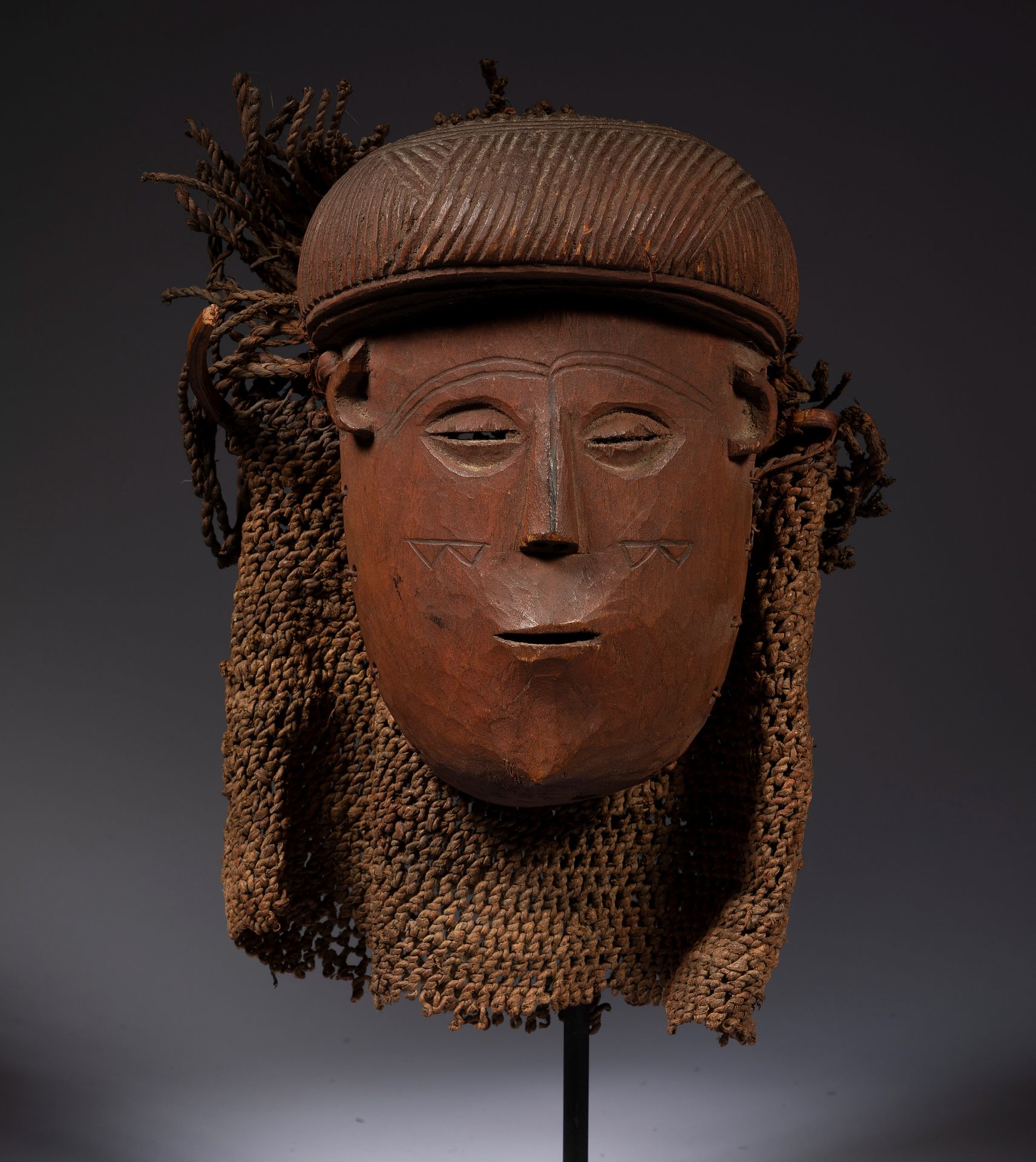 Null *一个带有雕刻头饰的古代疤痕面具，其古老的帽子和植物纤维编织的头饰。

Lwéna或Songo，安哥拉

木头、藤条、植物纤维和赭石颜料，小的可见事故&hellip;