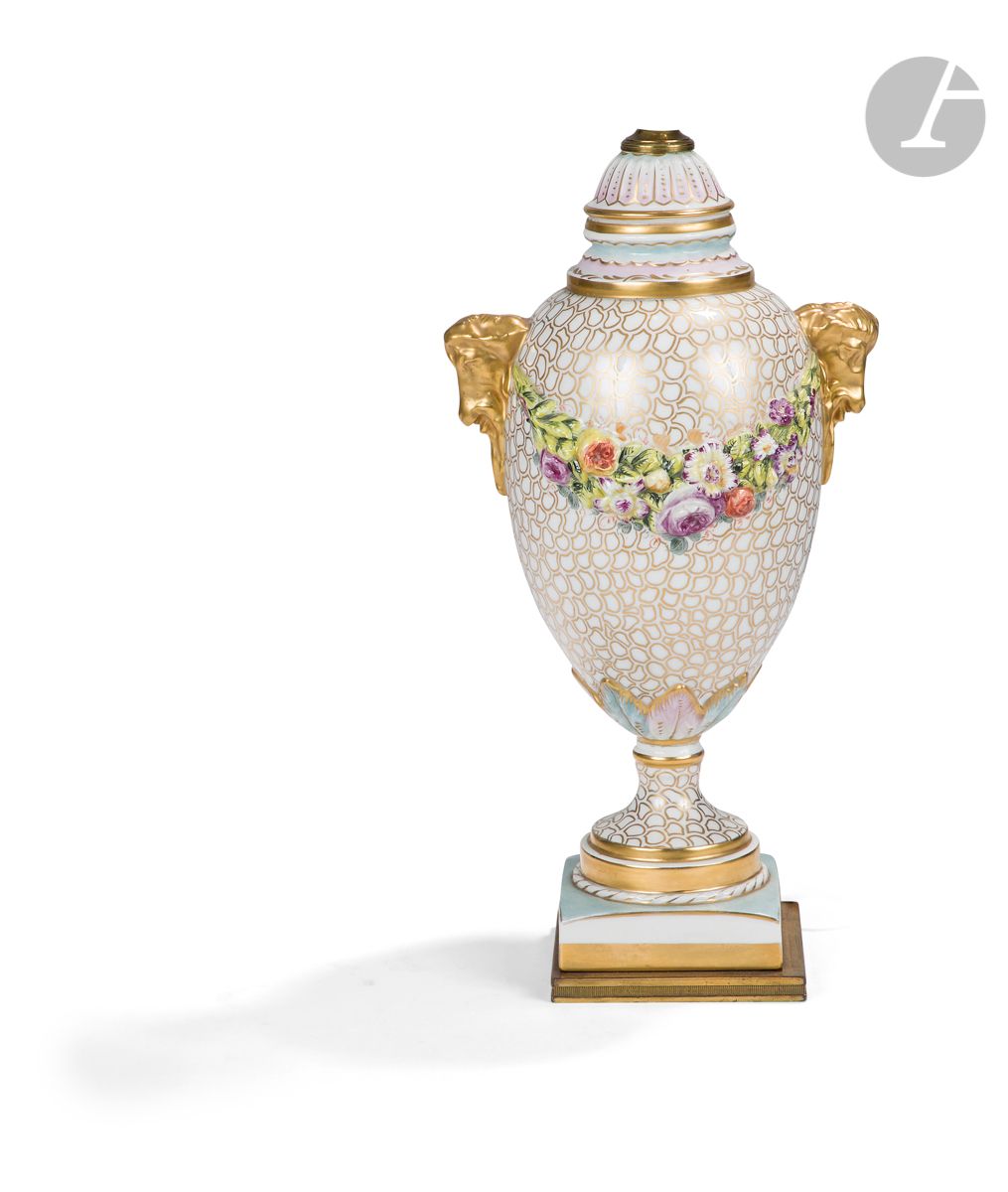 Null 巴黎
瓷器覆盖的柱形花瓶，手柄为金色背景的公羊头形状，金色卵石背景上有多色和浮雕的花环装饰。
20世纪。
高度：38厘米
被安装成一盏灯。