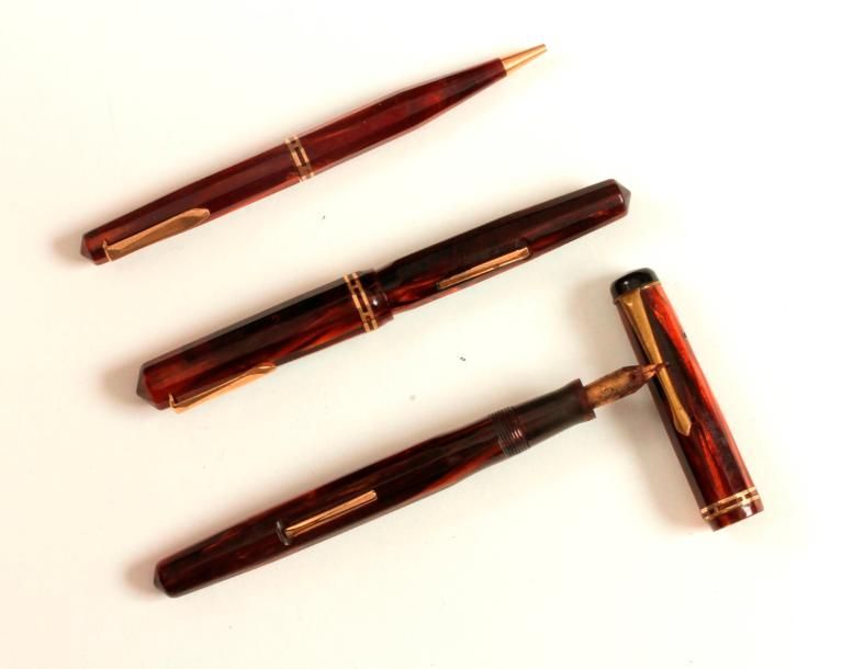 Null Lot de trois stylos en bakélite dont deux avec des plumes en or 18K.