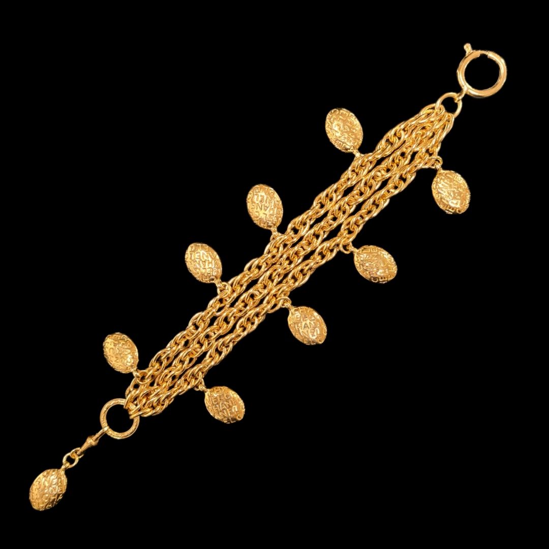 Null 卡尔-拉格斐（Karl Lagerfeld）约1990年设计的香奈儿（CHANEL）手镯--三条鎏金金属链，上面刻有品牌名称的图案。

盘上有签名。
&hellip;