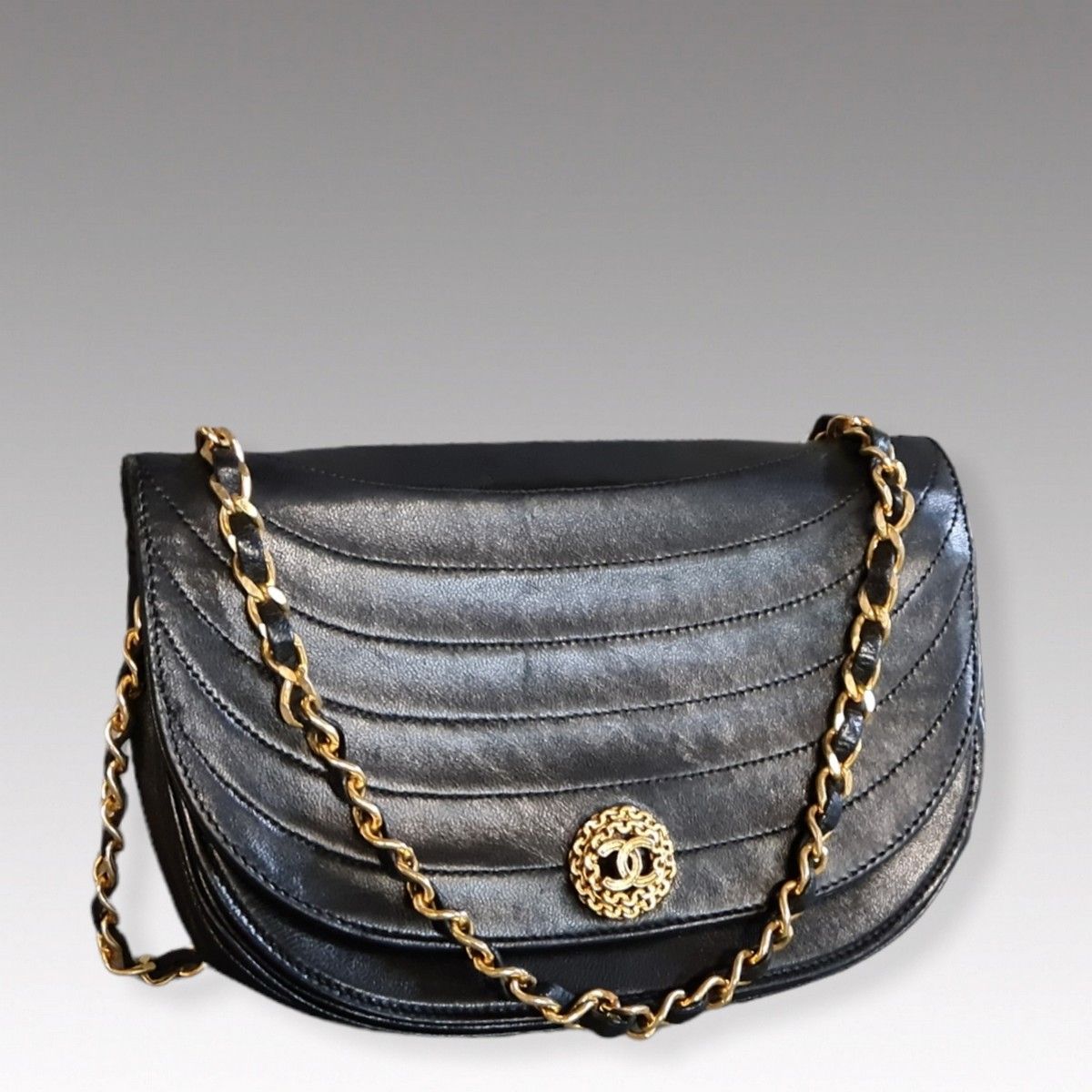 CHANEL circa 1995 - 21 cm half-moon bag in black lambskin leather with wavy  stitching, snap closure on flap, topped with the House's logo in a gilded  metal chain, chain handle intertwined
