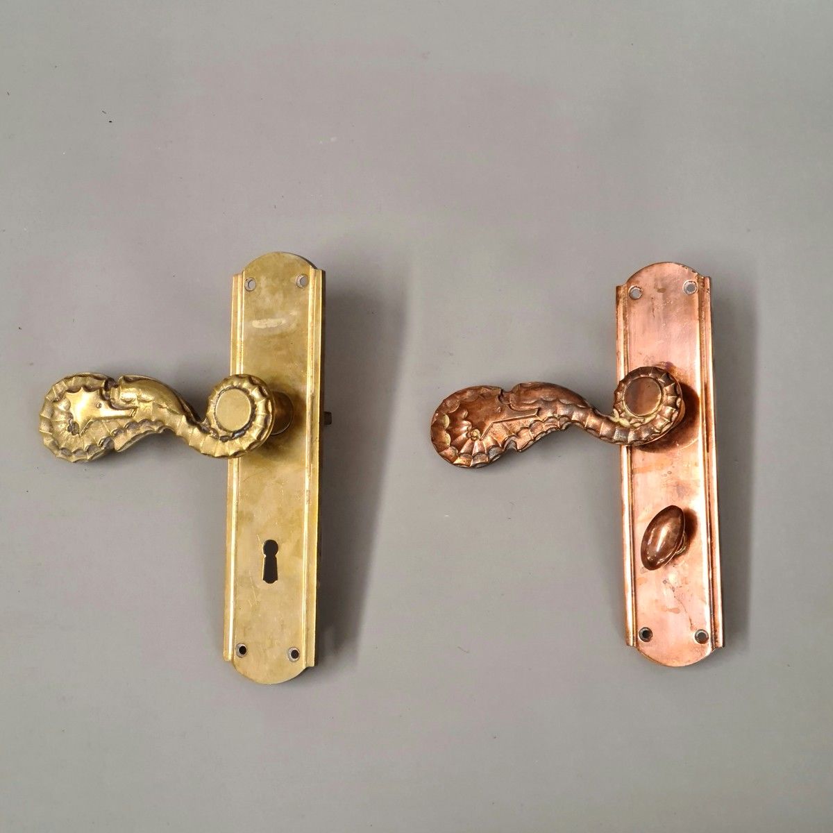 Null 2个门把手及其清洁板 1950年左右，黄铜和铜制，把手为海马形状

L. 22 cm

带有方形