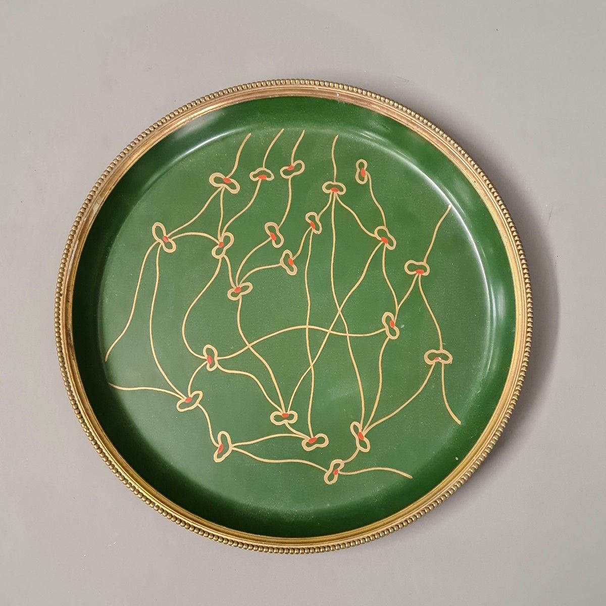 Null 装饰艺术风格的圆形漆面纸板托盘，绿色背景上有金色和红色的花纹装饰，镀金的黄铜框架上有珍珠装饰。

D. 27厘米