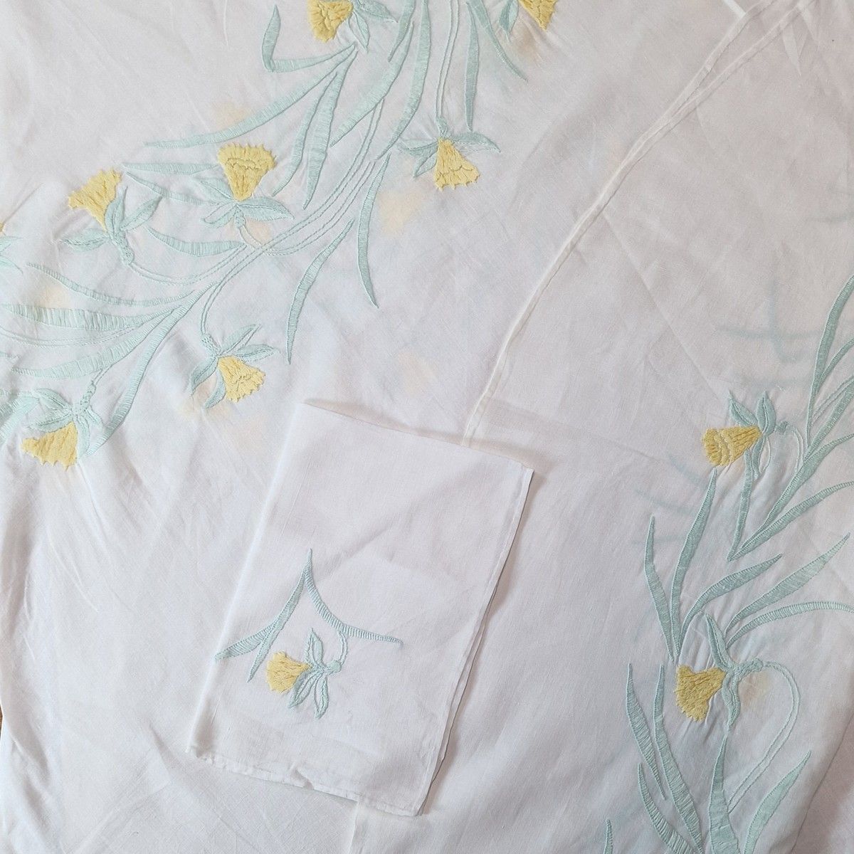 Null 约 1960 年用棉线缝制的牛皮围巾和 6 条毛巾套装，平针绣有黄绿相间的水仙花图案
205 厘米 x 196 厘米
BSC 
(按原样出售）