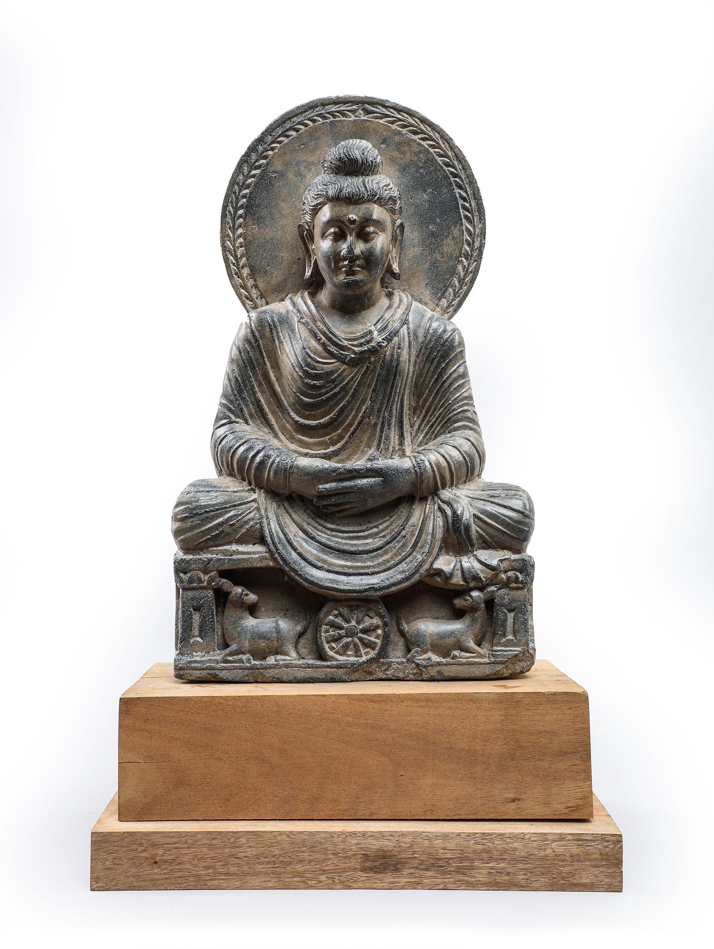 Null 
坐着的佛陀呈dyna-mudra姿势，是一种冥想的姿态，脑后有一个曼陀罗，底座上有车轮和片岩水牛的装饰。犍陀罗艺术 I / 5世纪

H.49厘米（&hellip;