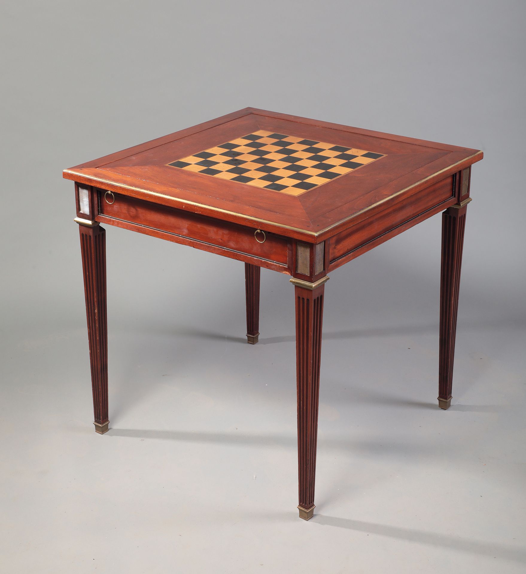 Null 方形红木游戏桌，两面旋转的桌面，有棋盘和棋子。

jaquet和棋盘游戏，凹槽 "Gaine "腿。

饰有珍珠楣和刮刀。

路易十六风格，19世纪
&hellip;