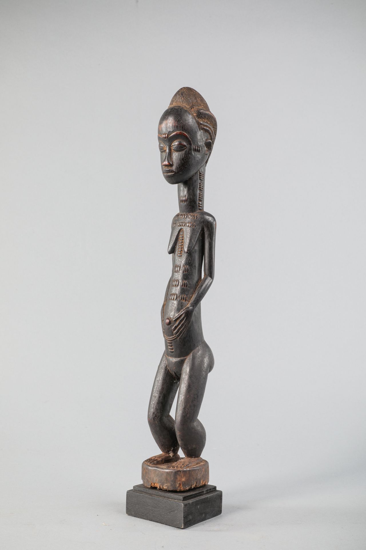 Null Statuette féminine Baoulé, Côte d'Ivoire. Bois, patine brun noir. H 46cm.