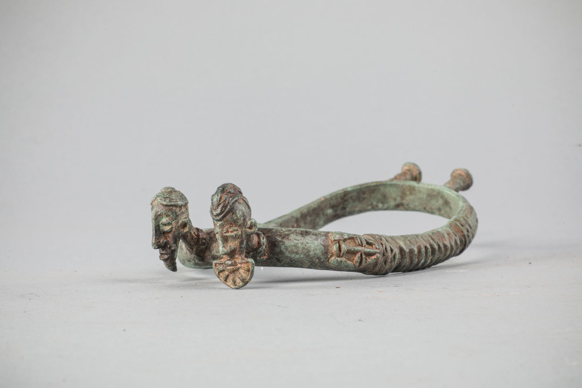 Null 多贡或洛比脚镯，马里/布基纳法索，装饰有两个头像和象征性的图案。带有灰绿色铜锈的青铜器。长20.5厘米。