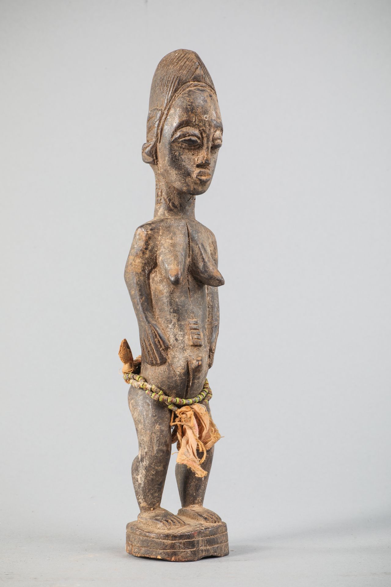 Null COTE D'IVOIRE - Estatua femenina BAOULE, madera, tela, abalorios, H 32 cm