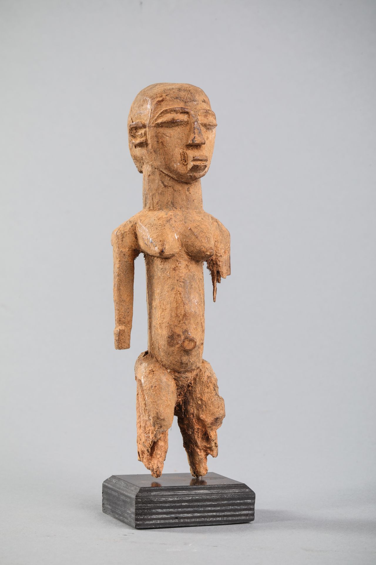 Null 洛比女性雕像，布基纳法索。坚硬的木头，有浅棕色，略带土黄色的铜锈，腿部有旧的侵蚀。高21厘米。