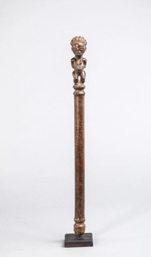 Null 象牙海岸的Baule权杖，顶部装饰有一个女性形象。木头，棕色赭石色斑纹。高57厘米。