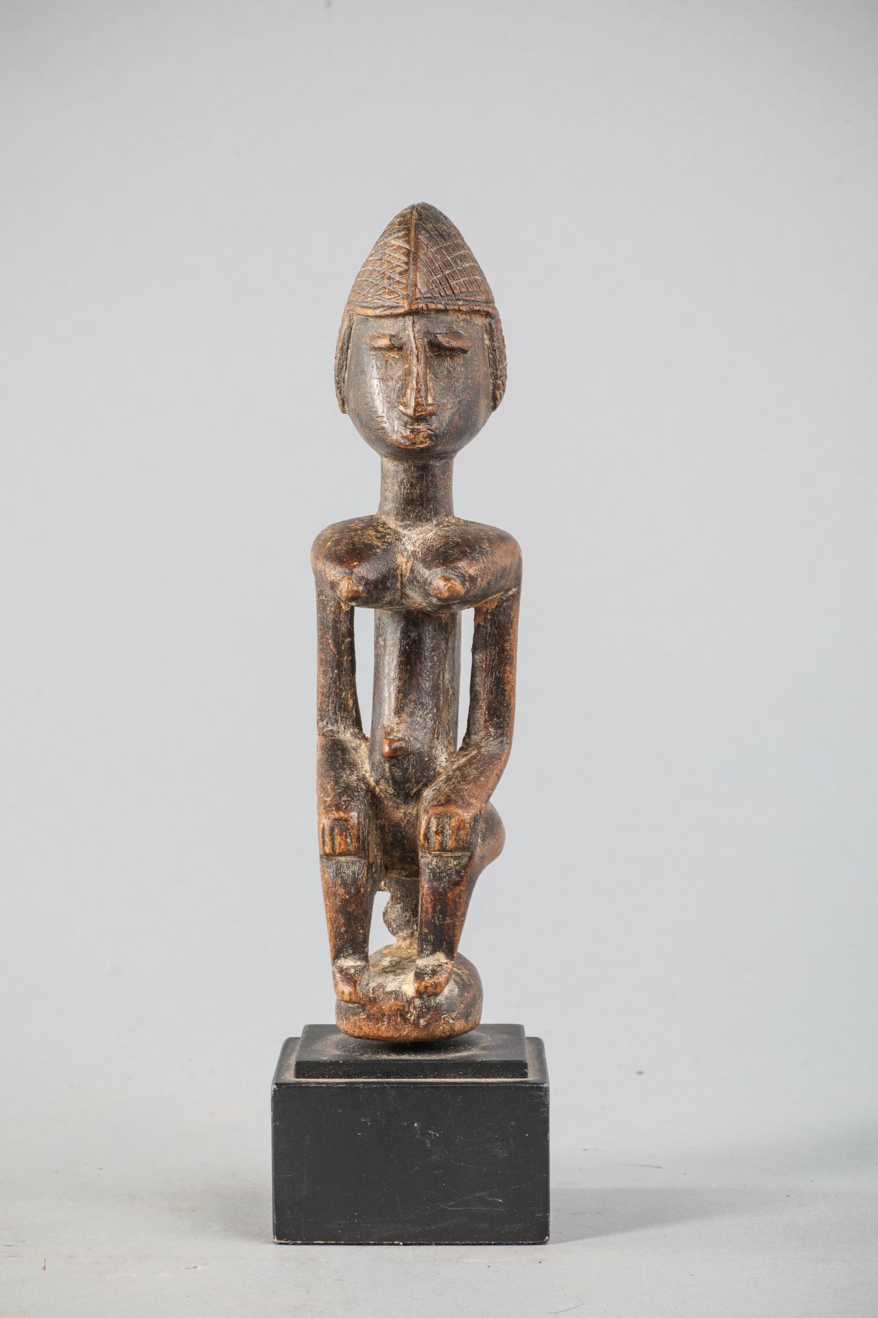 Null Dogon female figure, Mali, depicted seated. Wood, brown patina. H 20cm.