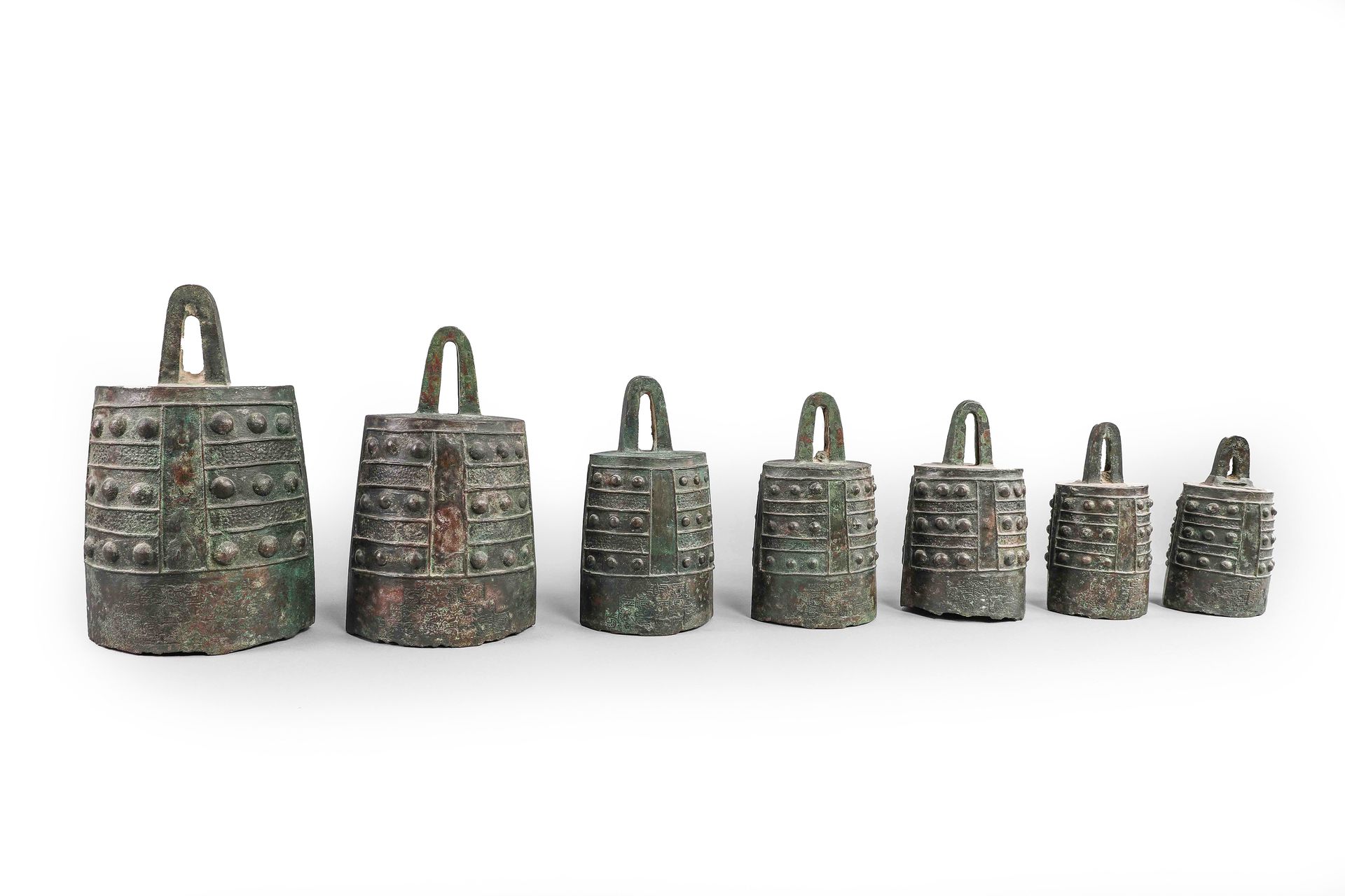 青铜 "雍仲 "七音钟，饰以十二个刻痕中的三个菱形，底部有一个陶质面具的造型。中国 汉代（公元前206年至公元220年） 高16厘米至27厘米 热释光试验