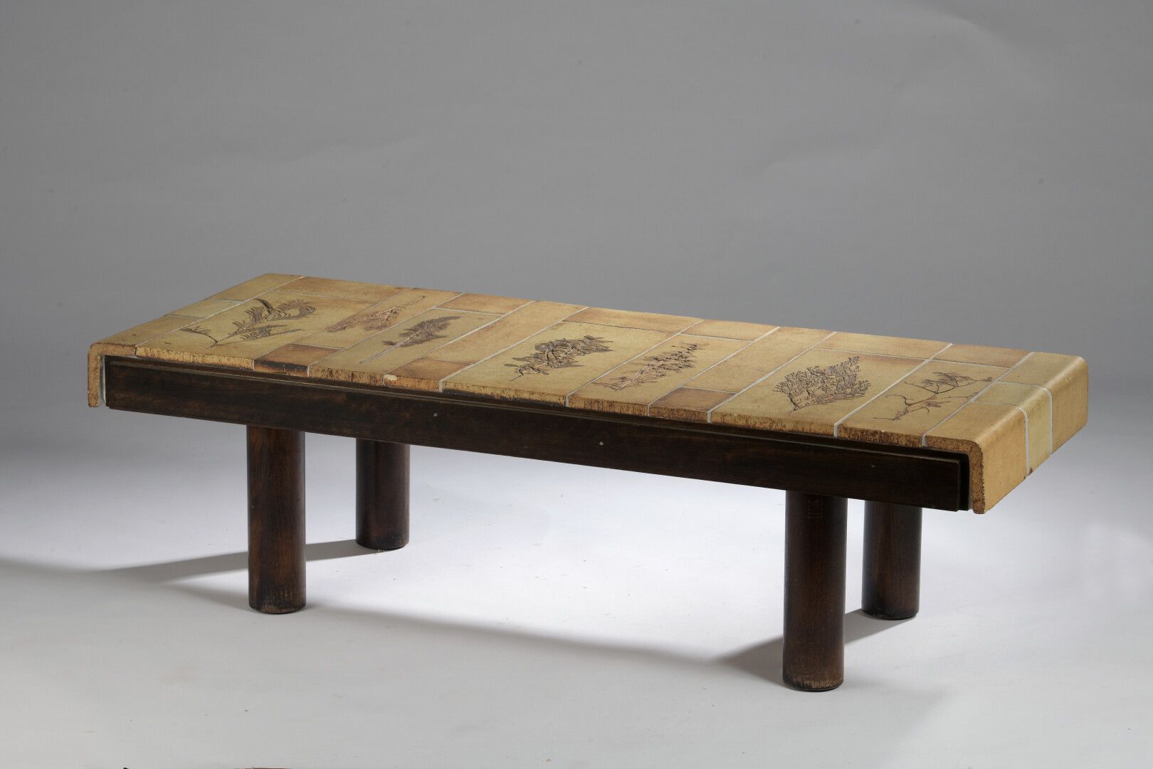 Null 罗杰-卡普隆（1922-2006）。清漆木质的长方形茶几，溢出的顶部衬有二十四块釉面石砖，有七个标本馆印刷品的棕色装饰，木质底座。签名并盖章

34 &hellip;