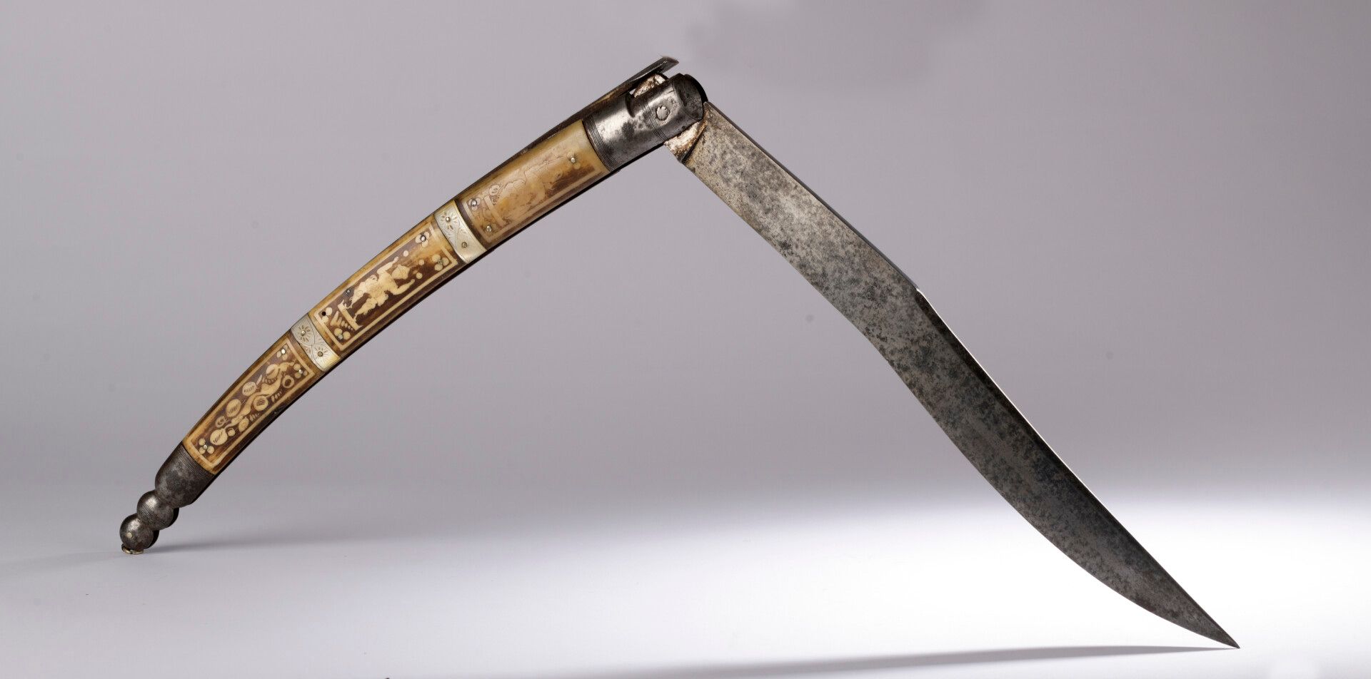 Null 狩猎刀，名为Navaja。折叠式刀片，带钢锁，手柄上有凸缘和刻有字符的雄鹿木板，与雕刻的珍珠母环交替装饰。可能是在夏特莱罗制作的，19世纪

长：72&hellip;