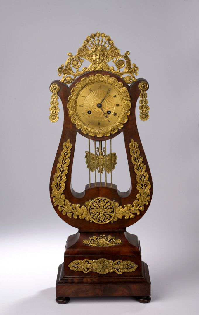 Null A mahogany veneered lyriform clock with a stepped base, a circular ormolu d&hellip;