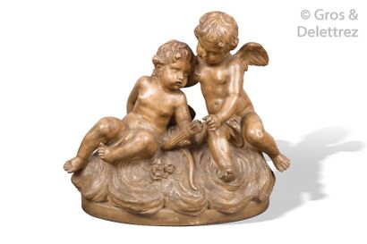 null Brown patinated terracotta group showing two loves sitting on a cloud holding...