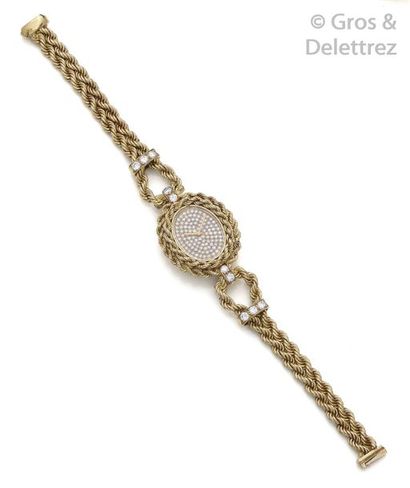 BOUCHERON Bracelet-montre de dame en or jaune, boîtier ovale, le cadran pavé de diamants...