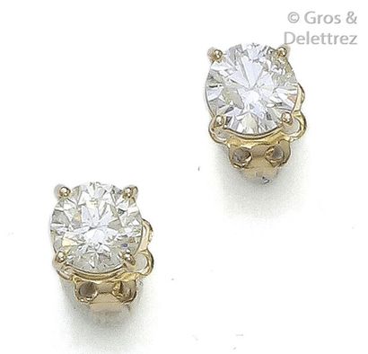 null Pair of yellow gold earrings, each adorned with a brilliant cut diamond weighing...