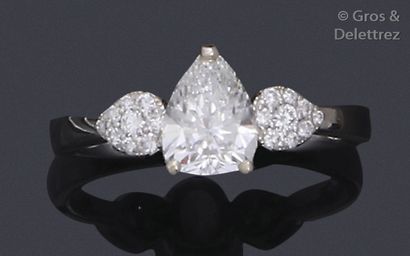 null White gold ring, adorned with a pear-shaped diamond, supported by drops paved...