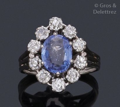 null White gold ring, adorned with a facetted oval sapphire in a setting of old-cut...