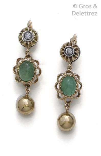 null Pair of yellow gold earrings, each adorned with a cabochon emerald surmounted...