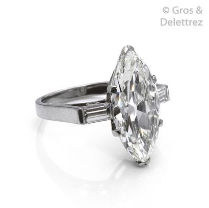 null Platinum ring, adorned with a shuttle-shaped diamond set with two baguette diamonds....