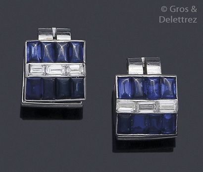 null Pair of platinum earrings each adorned with baguette and sapphire diamonds....