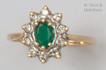 null Fleur" ring in yellow gold, adorned with an oval facetted emerald in a ring...