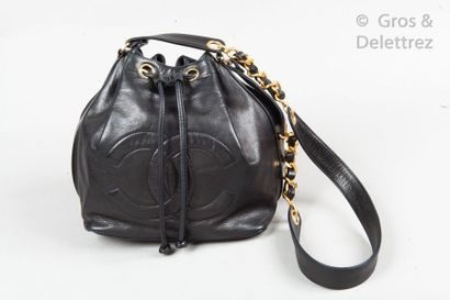 CHANEL Circa 1990 *Sac bourse 23cm en cuir agneau noir, fermeture par un lien coulissant,...