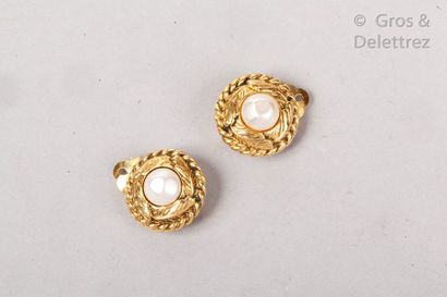 CHANEL Circa 1970

Pair of gilded metal ear clips with foliage motif in a rope surround,...