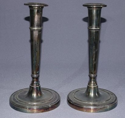 null Pair of candlesticks in silver plated metal, the shaft with cut sides, the circular...