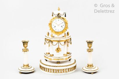 null White marble and gilded bronze trim consisting of a portico clock and two candlesticks....