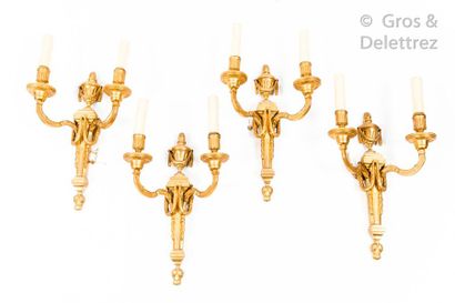 null Suite of four two-armed sconces in chased and gilded bronze with urn decoration,...