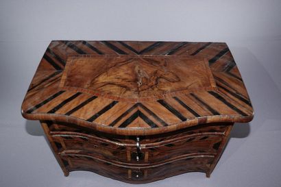 null Miniature chest of drawers in veneer inlaid with herringbone, the sinuous front...