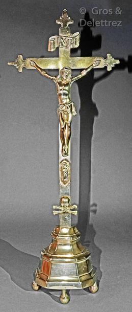 null Brass crucifix resting on three feet, the arms of the cross flowered. circa...