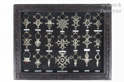 null Amulettes Touaregs en argent (21) dans un cadre en cuir estampé.