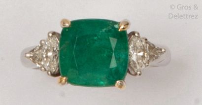 null White gold ring, decorated with a cushion emerald shouldered with shuttle and...