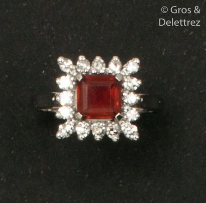 null White gold ring, set with a rectangular garnet in a circle of 8/8 cut diamonds....