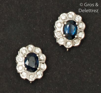 null Pair of white gold " Fleur " earrings, each adorned with an oval sapphire in...