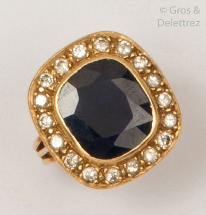 null Yellow gold ring set with an oval sapphire in a ring of brilliant-cut diamonds....