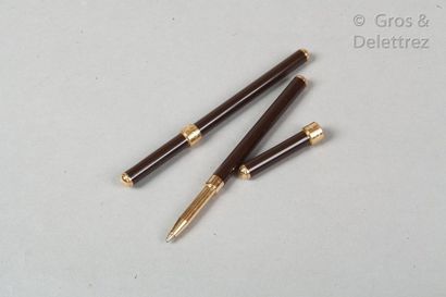 LOUIS VUITTON Lot de deux mini stylos à bille en laque marron et métal doré. Nous...