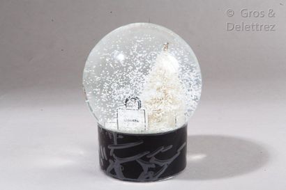 CHANEL Boule de neige figurant un sapin de Noël dans un entourage de paquets et de...