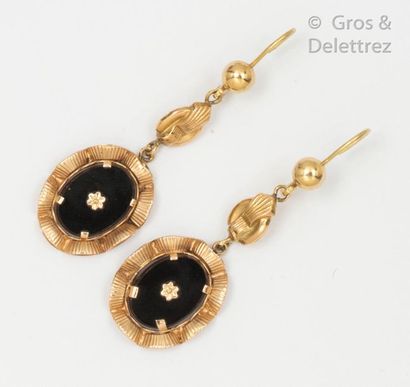 null Pair of yellow gold earrings, holding a stylized flower by an oval onyx plate...
