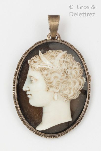 null Silver brooch with a large cameo on sardony representing a woman in profile....