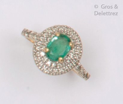 null Yellow gold ring, set with an oval emerald in a double ring of brilliant-cut...