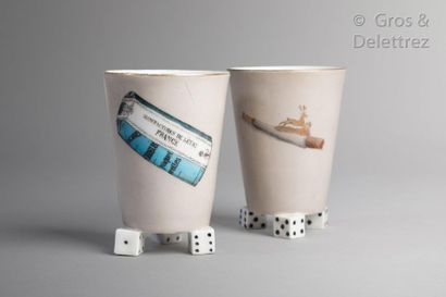 null Pair of truncated cone-shaped porcelain cups resting on three dice feet decorated...