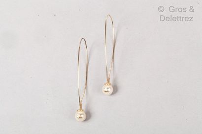 CHANEL Paire de créoles fil en métal doré retenant une perle blanche d’imitation...