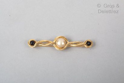 CHANEL Circa 1975

Broche barrette en métal doré torsadé, surmontée d’un motif perle...